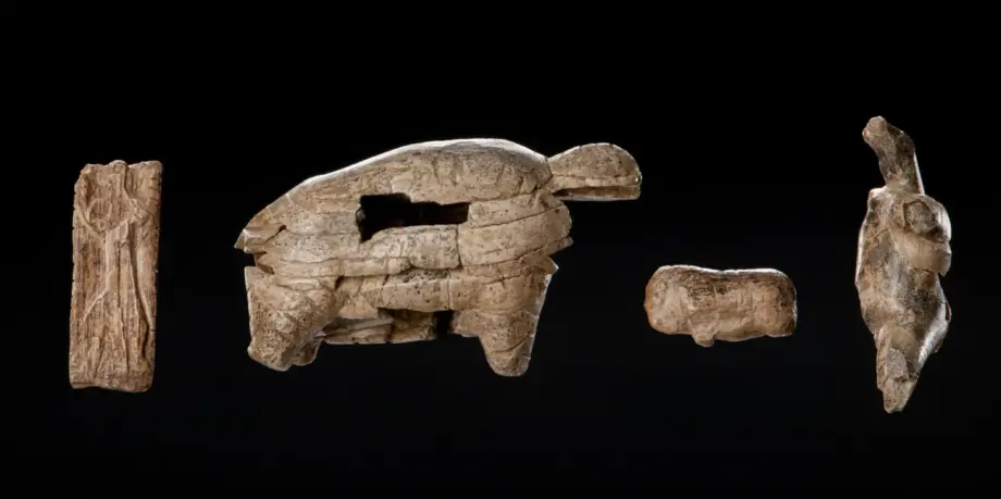 Vier Elfenbeinkunstwerke in verschiedenen Formen vor einem schwarzen Hintergrund